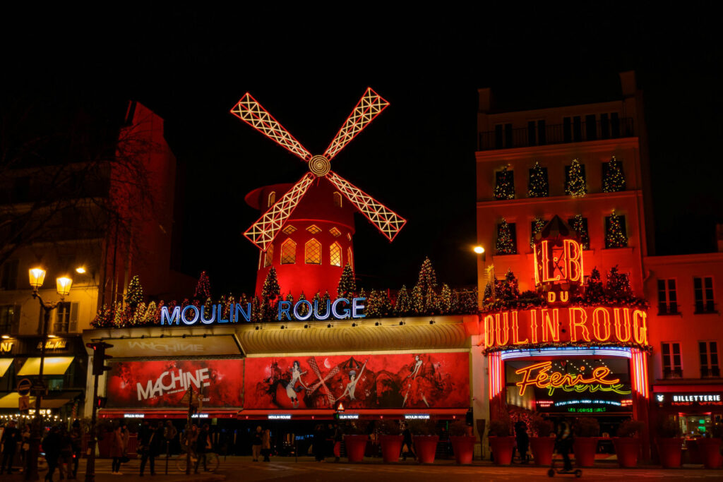 Moulin Rouge cabaret illuminated at night in Pigalle, Montmartre, Paris